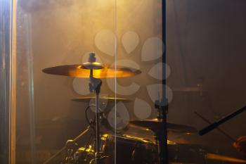 Live rock music photo background, rock drum set  with cymbals in warm stage lights. Close-up photo, soft selective focus