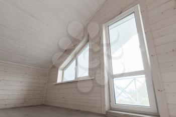 Empty white new wooden house interior, attic room with window and balcony door