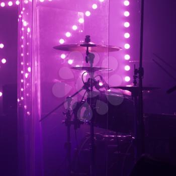 Live music photo background, rock drum set with cymbals in bright stage lights. Closeup photo, soft selective focus