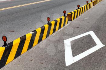 Concrete blocks with striped caution pattern, road fence construction