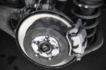 Close-up photo of brake disk and suspension springs. Replacing wheel on SUV car
