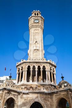 Facade of clock tower under blue sky, it was built in 1901 and accepted as the official symbol of Izmir City, Turkey
