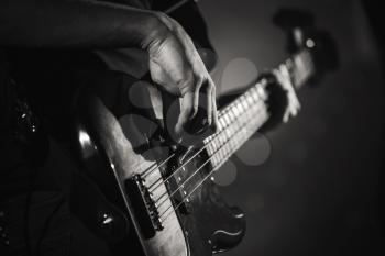 Electric bass guitar player hands, live music theme, close up black and white photo