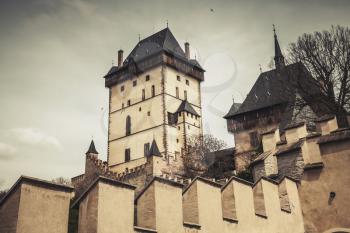 Karlstejn castle exterior. Gothic castle founded 1348 CE by Charles IV, Holy Roman Emperor-elect and King of Bohemia. Karlstejn village, Czech Republic. Vintage toned photo