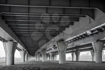 Dark urban scene under modern automotive bridge
