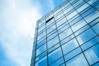 Modern office building wall made of steel and glass with blue sky