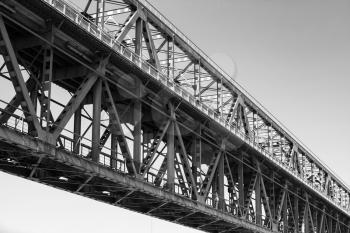 Steel truss bridge construction fragment with two levels of transportation, monochrome