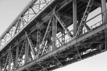 Steel truss bridge construction fragment with two levels of transportation, black and white