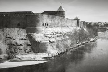 Ivangorod fortress at Narva river in winter season. Border between Russia and Estonia. Monochrome retro stylized photo