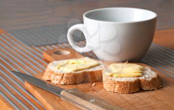 Simple breakfast background with white tea cap and bread and butter