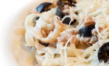 Spaghetti with tuna, olives and cheese closeup