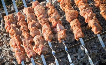 Shish kebab. Slices of meat with sauce cooking on hot coals