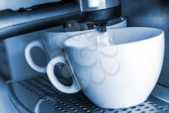 Empty white ceramic cups in espresso coffee machine.