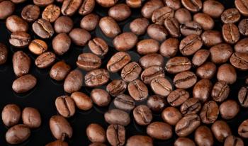 Background texture of roasted coffee beans on black background