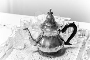 Metal Arabic teapot with glasses, black and white photo