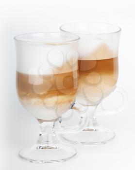Two glass mugs with handles of latte coffee, macro photo