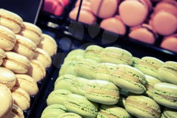 Colorful traditional French macarons lay  in the bakery. Toned photo with filter effect