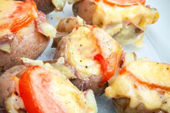 Hot homemade baked potato with tomato, bacon and cheese