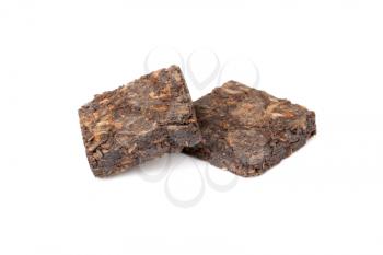 Two small pressing briquette of black Chinese Shu Pu Erh tea isolated on white background, selective focus with shallow DOF