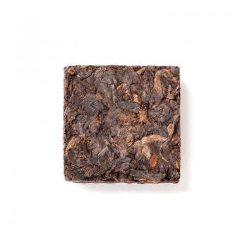 Small pressing briquette of black Chinese Shu Pu-erh tea isolated on white background, top view