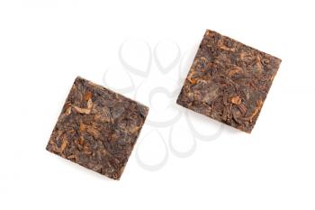Two small briquette of black Chinese Shu Pu-erh tea isolated on white background, top view