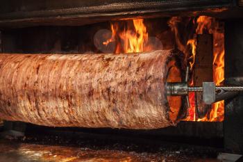 Traditional Turkish doner kebab is preparing in an oven with open fire