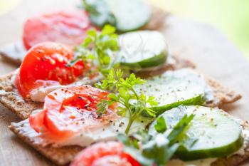 Healthy food, bright sandwiches. Finnish rye crisp bread, soft cheese, cucumber, tomato, parsley and black pepper