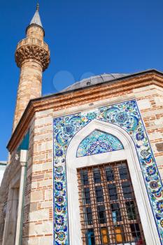 Ancient Camii mosque facade with Arabic decoration patterns and minaret. Konak square, Izmir, Turkey