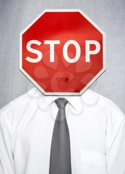 Man in white shirt with tie over gray background with stop road sign as a head. Business concept metaphor of failure, stress, ban