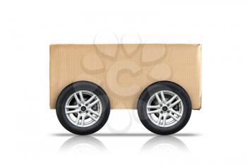 Cardboard box with automotive wheels isolated on white background, self delivery concept metaphor 