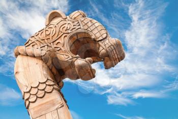 Carved wooden dragon on the bow of Viking ship above dramatic blue sky