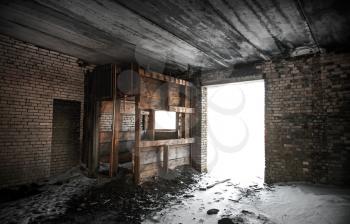 Old grunge abandoned barn interior with glowing exit