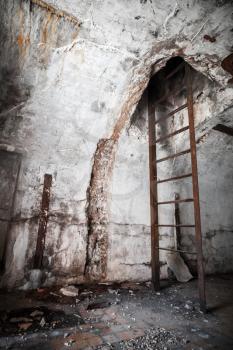 Old abandoned empty bunker interior with white walls and rusted constructions