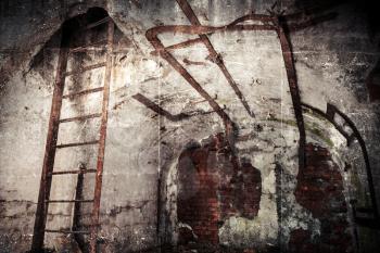 Old abandoned empty bunker interior with white walls and rusted constructions. Vintage toned photo with retro style filters