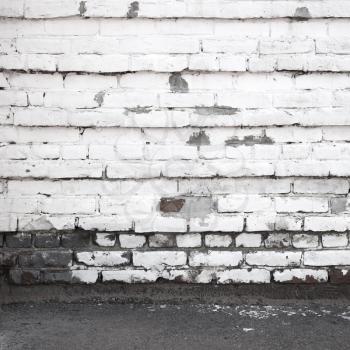 Urban background interior with old white brick wall and asphalt