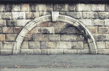 Stone wall with decorative arch, vintage architecture background texture with old style toned filter effect