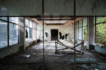 Abandoned building interior. Hall perspective with dirt on the floor and broken windows
