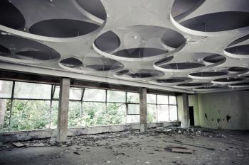 Abandoned industrial building interior. Empty hall with round pattern on ceiling