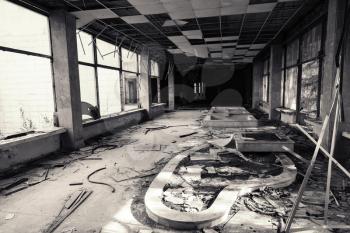 Abandoned building interior. Corridor perspective with many damages. Vintage monochrome toned photo, old style