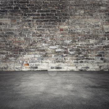 Empty abstract interior background with dark old brick wall and asphalt floor
