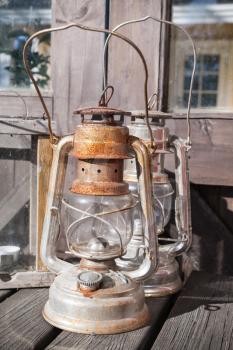 Rusted kerosene lamps stands on outdoor wooden table in Finland