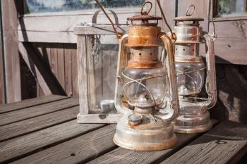 Rusted kerosene lamps stands on old outdoor wooden table in Finland