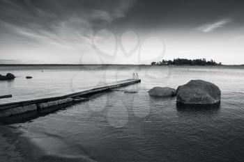 Saimaa lake landscape with wooden pier for swimming. Black and white photo with high contrast filter effect