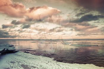 Winter coastal landscape with floating ice. Gulf of Finland, Russia. Vintage toned photo with filter effect