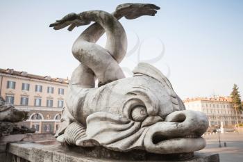 Ancient sculpture with fishes on the Piazza del Popolo square, old city center of Rome, Italy