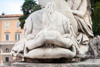Ancient sculpture of fish on the Piazza del Popolo square, old city center of Rome, Italy