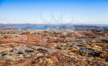 Spring Norwegian mountain landscape with coastal rocks under blue sky