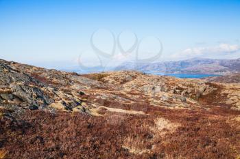 Spring Norwegian mountain landscape with flat rocks under blue sky