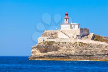 Madonetta lighthouse tower on coastal rock. Entrance to Bonifacio port, France. Mountainous Mediterranean island Corsica, Corse-du-Sud