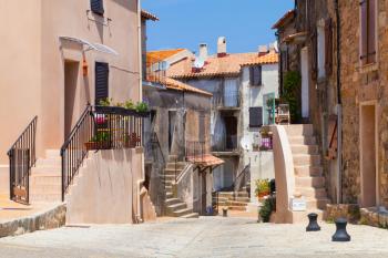 Narrow street of Piana town in bright summer day. Corsica island, France